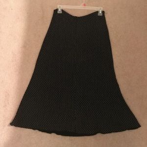A black midi skirt with cream polka dots